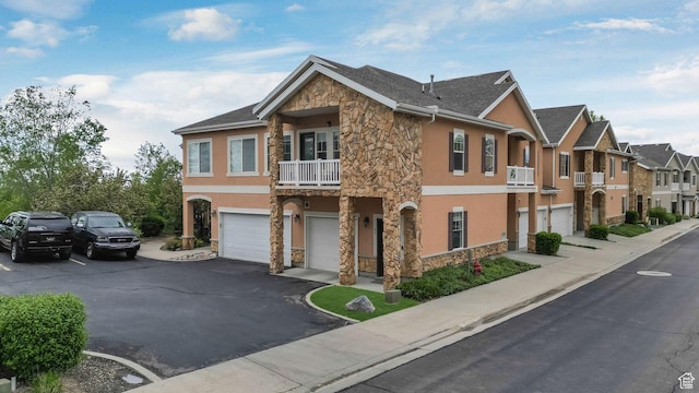 1138 S Meadow Fork Rd E Unit 3, Provo, UT 84606 - view of front of home featuring stone siding, stucco siding, an attached garage, a residential view, and a balcony