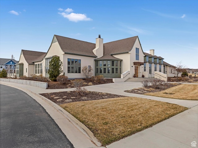 11126 S Kiwano Way S, Jordan, UT 84009 - view of front of home featuring a chimney, a front yard, roof with shingles, a residential view, and stucco siding