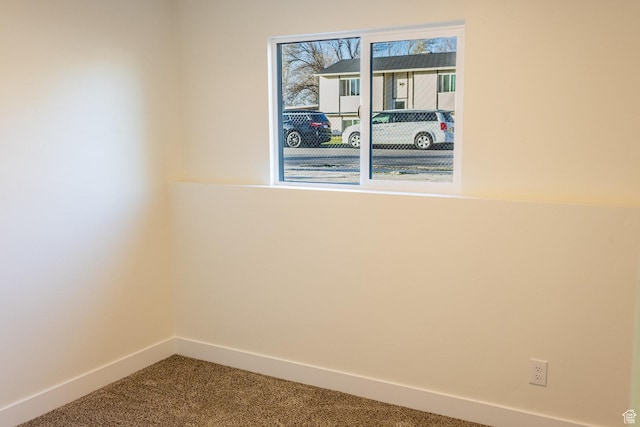 carpeted spare room with baseboards