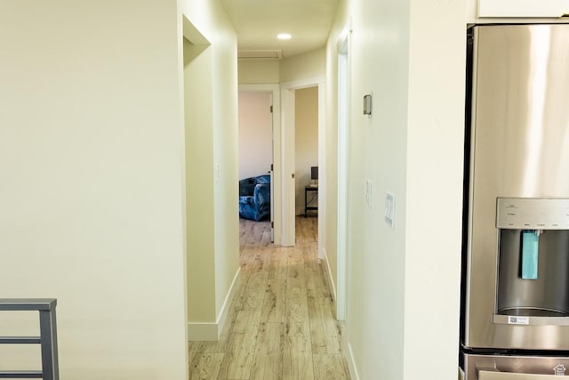 hallway featuring baseboards and light wood-type flooring