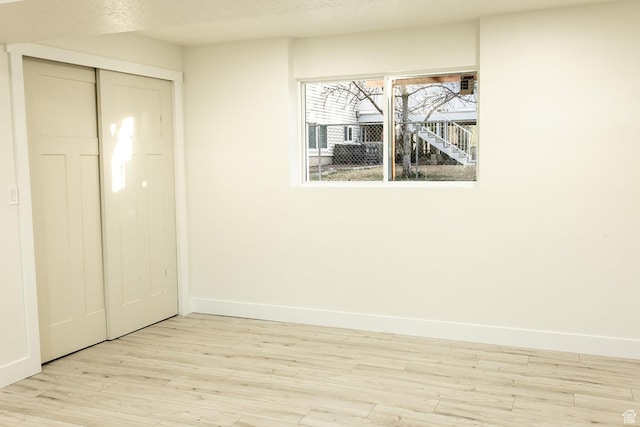 unfurnished bedroom with baseboards, a closet, wood finished floors, and a textured ceiling