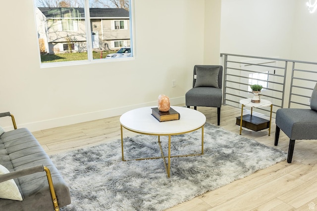 living area with baseboards and wood finished floors