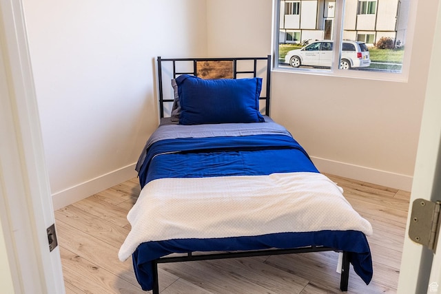 bedroom with baseboards and wood finished floors