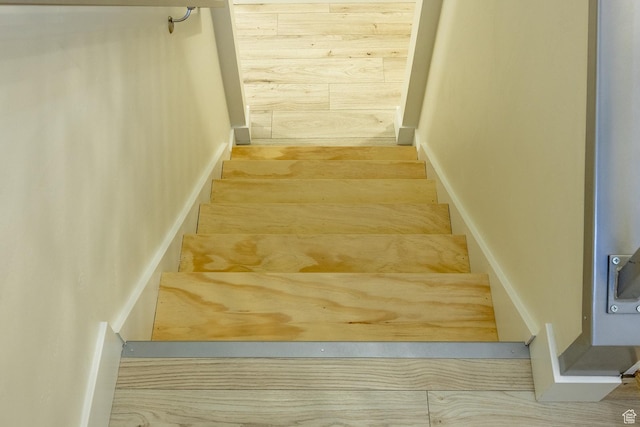 stairs featuring wood walls
