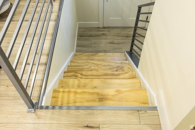 stairs featuring wood finished floors