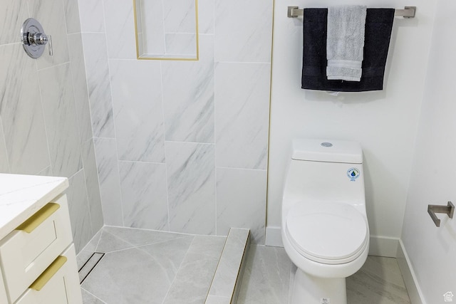 bathroom with toilet, vanity, and baseboards