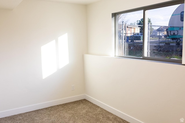 unfurnished room featuring carpet floors and baseboards