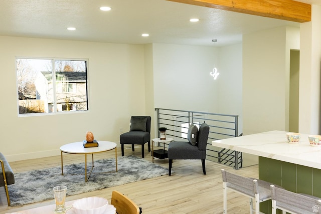 sitting room with baseboards, an upstairs landing, recessed lighting, and light wood finished floors