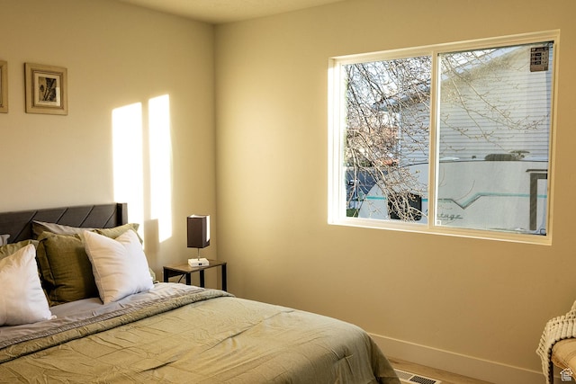 bedroom with baseboards and visible vents
