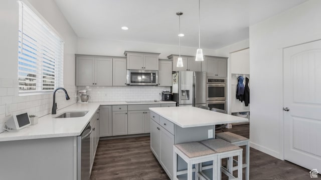 442 Doubleday St, Mapleton, UT 84664 - kitchen featuring a breakfast bar, stainless steel appliances, a sink, gray cabinetry, and backsplash