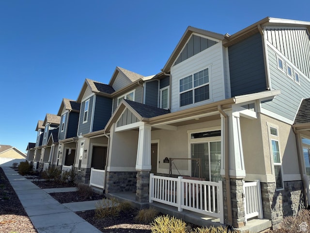 5264 S Tucker Ct W Unit 329, West Valley City, UT 84118 - view of front of house featuring a residential view, stucco siding, a porch, and stone siding