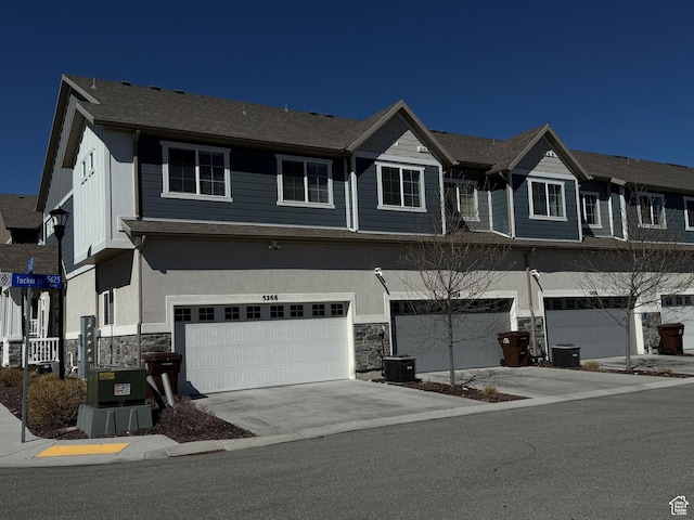 5264 S Tucker Ct W Unit 329, West Valley City, UT 84118 - view of property with stone siding, stucco siding, driveway, and a garage