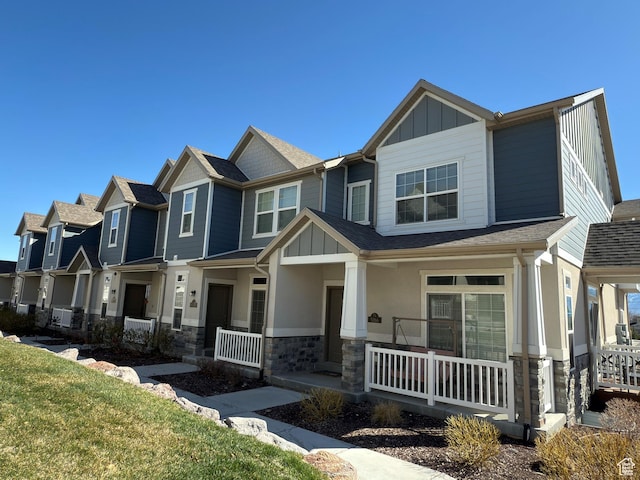5264 S Tucker Ct W Unit 329, West Valley City, UT 84118 - craftsman-style house featuring covered porch, stone siding, board and batten siding, a front lawn, and a residential view