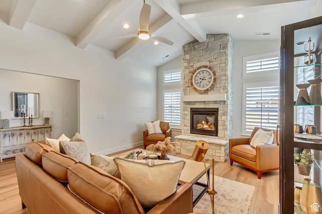 living area featuring ceiling fan, beam ceiling, plenty of natural light, and light wood finished floors
