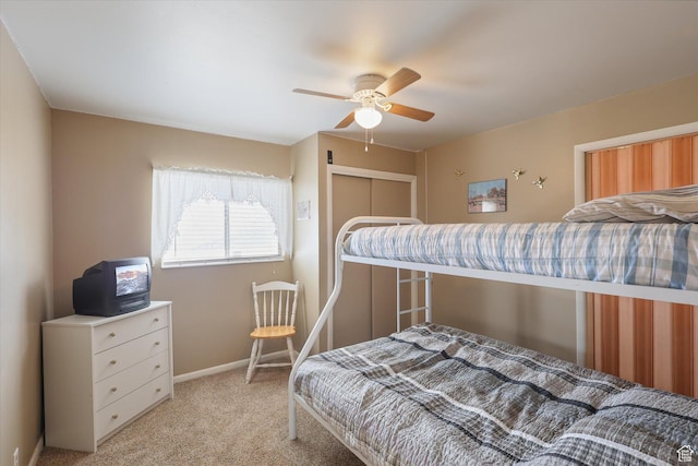 bedroom with baseboards, a closet, carpet flooring, and a ceiling fan