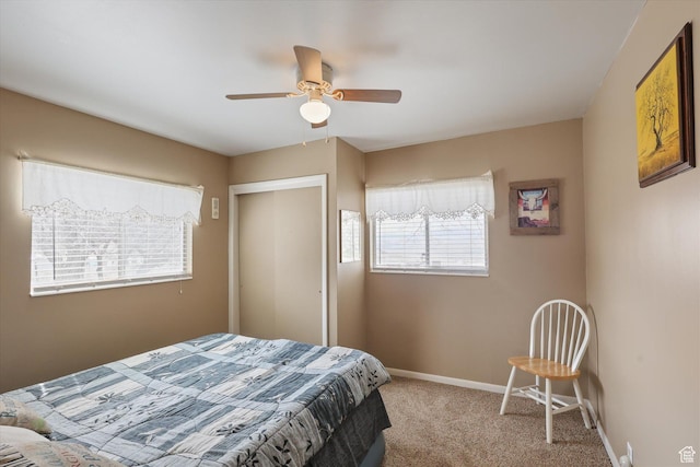bedroom featuring light colored carpet, baseboards, and a ceiling fan