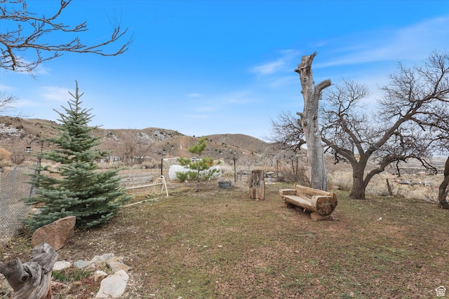 view of yard featuring fence and a mountain view