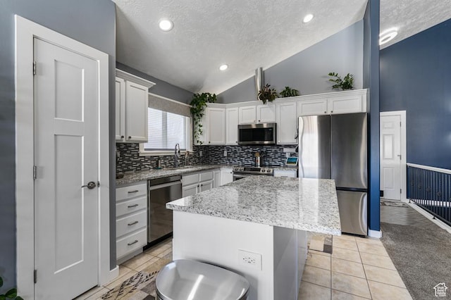 6718 W Halter Creek Way S, West Valley City, UT 84128 - kitchen featuring lofted ceiling, light tile patterned floors, a center island, white cabinets, and appliances with stainless steel finishes