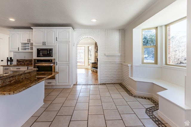 945 Church St, Layton, UT 84041 - kitchen featuring arched walkways, black microwave, light tile patterned floors, and oven