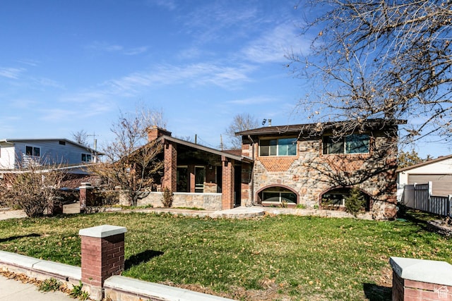 945 Church St, Layton, UT 84041 - view of front of home with stone siding, brick siding, fence, and a front lawn