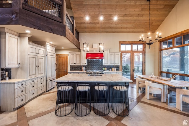 5956 N Triple Crown Trl, Oakley, UT 84055 - kitchen with light stone countertops, a notable chandelier, high vaulted ceiling, and tasteful backsplash