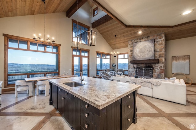 5956 N Triple Crown Trl, Oakley, UT 84055 - kitchen with wood ceiling, a sink, a fireplace, open floor plan, and an inviting chandelier