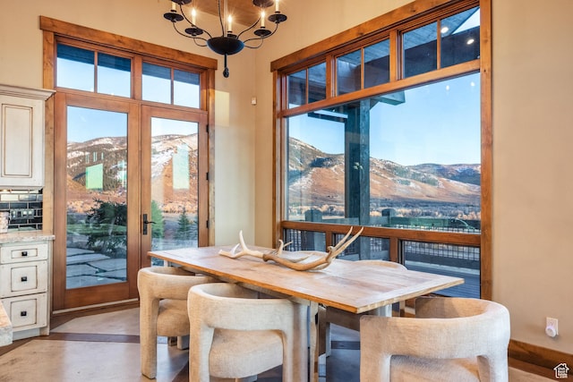 5956 N Triple Crown Trl, Oakley, UT 84055 - dining room featuring concrete floors, a wealth of natural light, a chandelier, and a mountain view