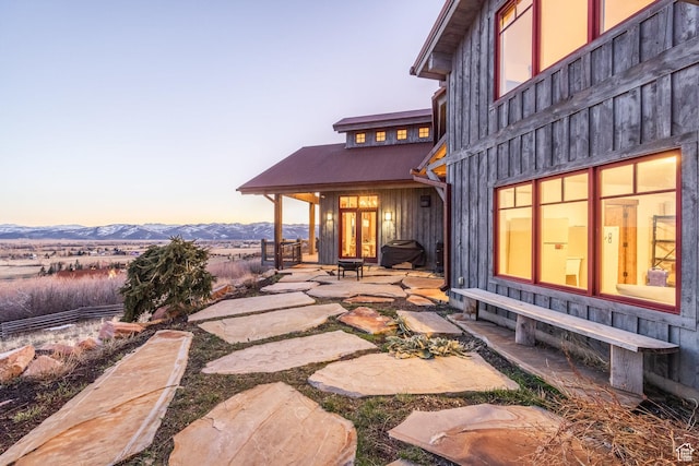 5956 N Triple Crown Trl, Oakley, UT 84055 - patio terrace at dusk with french doors, grilling area, and a mountain view