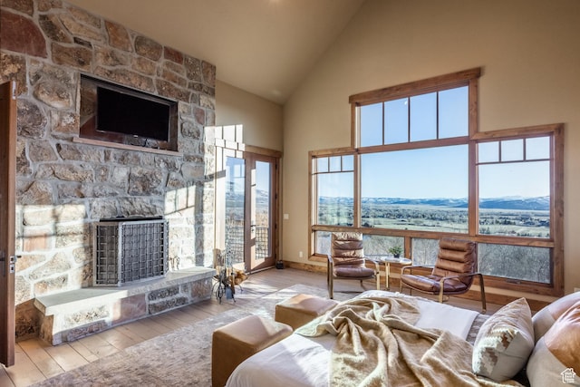 5956 N Triple Crown Trl, Oakley, UT 84055 - living room featuring a stone fireplace, baseboards, high vaulted ceiling, and hardwood / wood-style flooring
