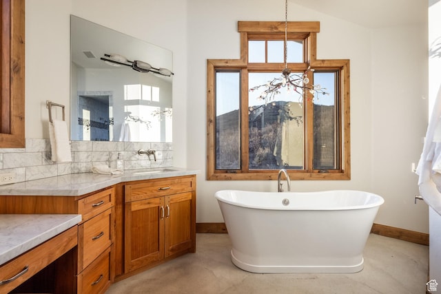 5956 N Triple Crown Trl, Oakley, UT 84055 - bathroom with a freestanding bath, vanity, tasteful backsplash, and baseboards