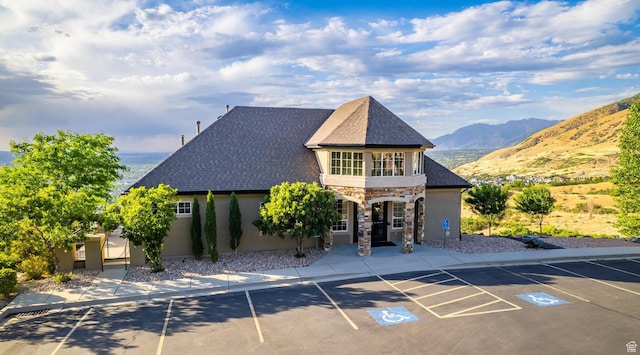 14146 S Spyglass Hill Dr, Draper, UT 84020 - view of front facade featuring stone siding, uncovered parking, a mountain view, stucco siding, and roof with shingles