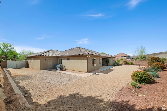 1041 E Silver Shadows Dr, Washington, UT 84780 - back of property with a fenced backyard, a tile roof, stucco siding, and a patio