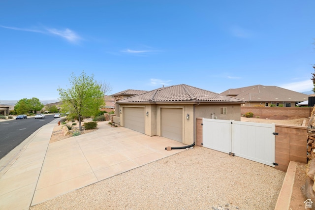 1041 E Silver Shadows Dr, Washington, UT 84780 - view of front of home featuring stucco siding, fence, a tiled roof, a gate, and a garage