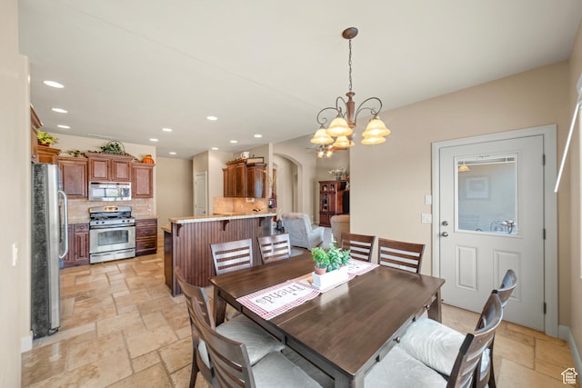 1041 E Silver Shadows Dr, Washington, UT 84780 - dining space with a notable chandelier, stone tile floors, arched walkways, and recessed lighting