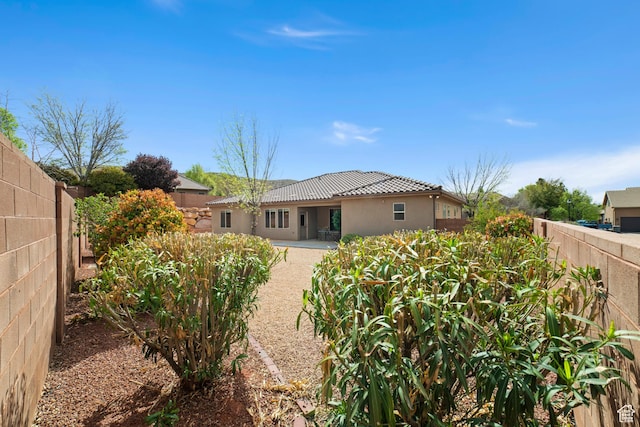 1041 E Silver Shadows Dr, Washington, UT 84780 - back of house with a patio, a tiled roof, stucco siding, and a fenced backyard