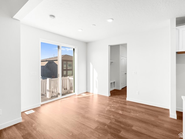 963 W Ruddy Clover Ln Unit 282, Saratoga Springs, UT 84045 - unfurnished room with wood finished floors, a textured ceiling, baseboards, and visible vents