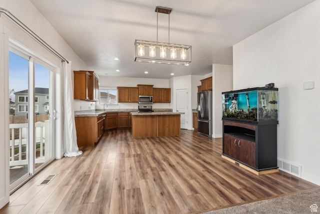 4 E Sterling Loop, Vineyard, UT 84059 - kitchen featuring brown cabinets, visible vents, wood finished floors, and stainless steel appliances