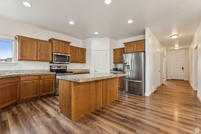 4 E Sterling Loop, Vineyard, UT 84059 - kitchen featuring a kitchen island, appliances with stainless steel finishes, dark wood-type flooring, and brown cabinets
