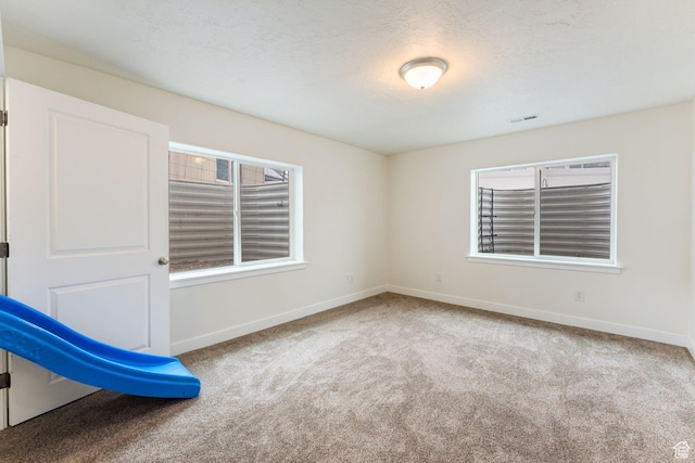 4 E Sterling Loop, Vineyard, UT 84059 - empty room featuring carpet flooring, baseboards, a textured ceiling, a wealth of natural light, and visible vents