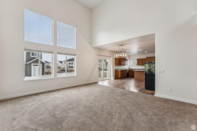 4 E Sterling Loop, Vineyard, UT 84059 - unfurnished living room featuring carpet flooring, a towering ceiling, baseboards, and recessed lighting