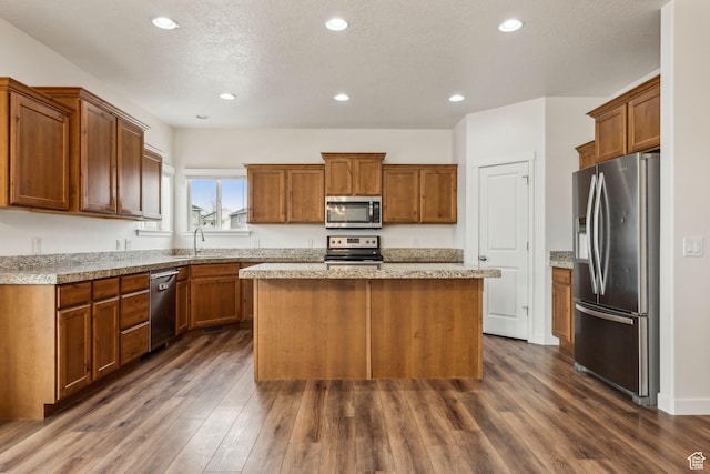 4 E Sterling Loop, Vineyard, UT 84059 - kitchen with a sink, appliances with stainless steel finishes, a center island, brown cabinets, and dark wood-type flooring