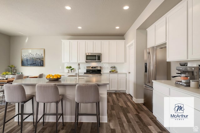 3807 W 1760 S Unit 206, Taylor, UT 84401 - kitchen featuring white cabinets, a kitchen bar, a sink, and stainless steel appliances