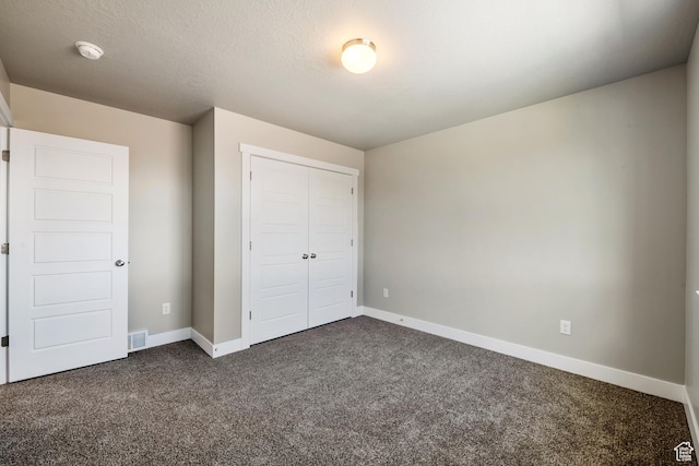 3807 W 1760 S Unit 206, Taylor, UT 84401 - unfurnished bedroom featuring a closet, a textured ceiling, visible vents, baseboards, and dark colored carpet