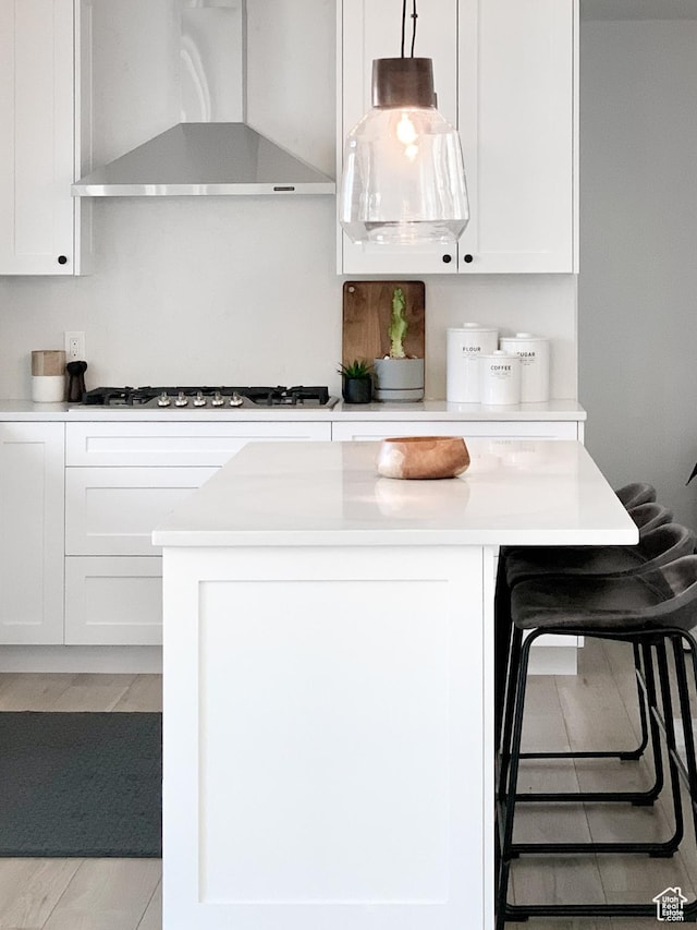 5188 S Saddleback Dr, Holladay, UT 84117 - kitchen with wall chimney exhaust hood, light countertops, white cabinets, and a center island
