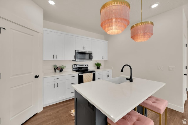 499 N 420 W Unit 138, Lindon, UT 84042 - kitchen with a kitchen bar, stainless steel microwave, a sink, electric range oven, and wood finished floors