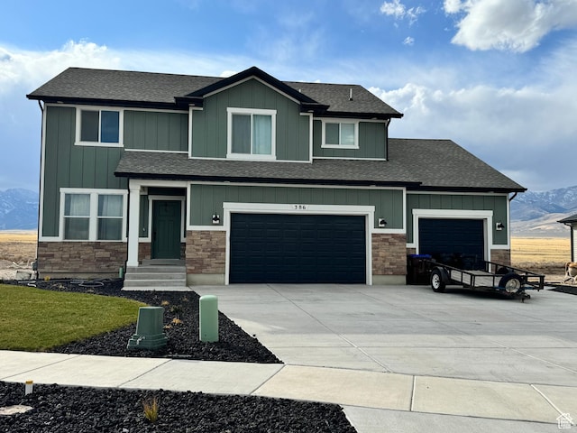 craftsman-style house with stone siding, board and batten siding, and concrete driveway