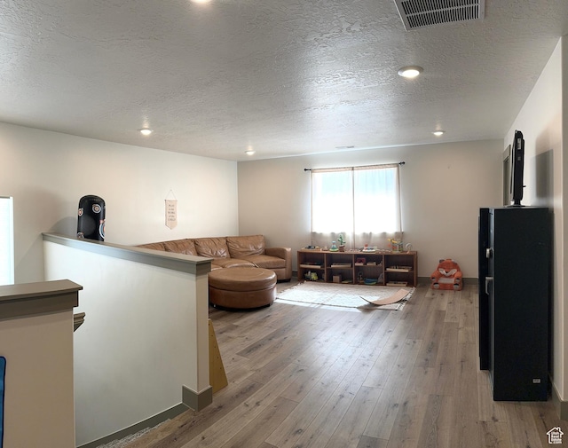 386 S Amber Field Dr Unit 508, Grantsville, UT 84029 - living room featuring recessed lighting, a textured ceiling, light wood finished floors, and visible vents