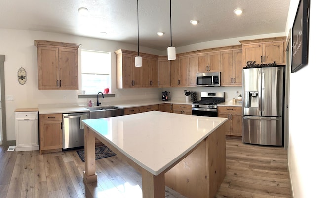 386 S Amber Field Dr Unit 508, Grantsville, UT 84029 - kitchen with light countertops, stainless steel appliances, a sink, pendant lighting, and light wood finished floors
