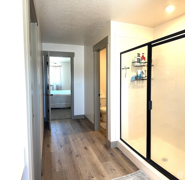 386 S Amber Field Dr Unit 508, Grantsville, UT 84029 - ensuite bathroom with toilet, a textured ceiling, a shower stall, hardwood / wood-style flooring, and ensuite bathroom