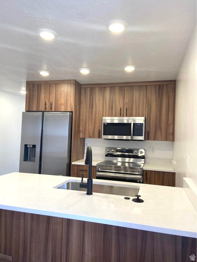 386 S Amber Field Dr Unit 508, Grantsville, UT 84029 - kitchen with light countertops, stainless steel appliances, modern cabinets, and brown cabinets